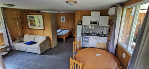 a kitchen and a living room with a table in a room at Fonyód Camping & Apartman in Fonyód