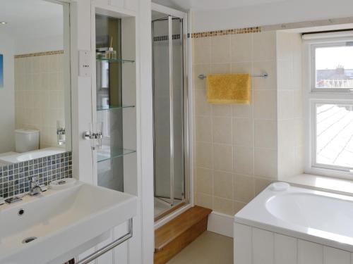 a white bathroom with a sink and a shower at Lime Cottage in Portland