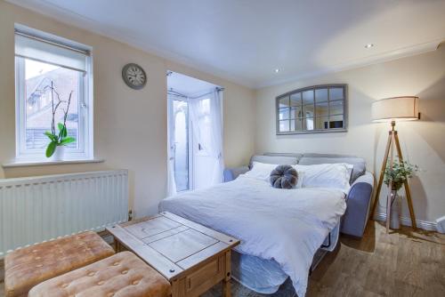 Schlafzimmer mit einem Bett, einem Tisch und einem Fenster in der Unterkunft Pass the Keys Beautiful Cosy Home in Basildon