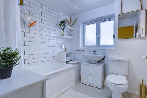 a white bathroom with a toilet and a sink at Pass the Keys Beautiful Cosy Home in Basildon