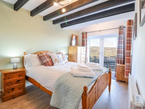 a bedroom with a large bed and a window at Alwyn Cottage in Llangollen