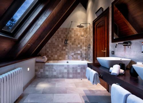 y baño con bañera y lavamanos. en Hotel de Tredós Baqueira, Affiliated by Meliá en Tredós