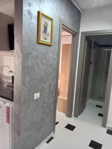 a kitchen with a gray wall with a picture on it at Apartament 2 dormitoare și living bloc nou in Năvodari