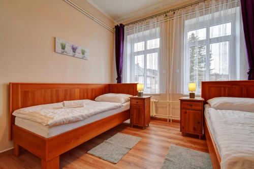 a bedroom with two beds and a window at Penzion pod Radyni in Starý Plzenec