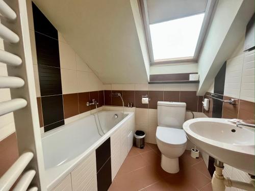 a bathroom with a white toilet and a sink at Penzion Félix in Topoľčany