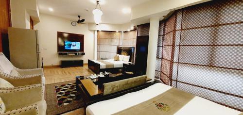 a hotel room with a bed and a television at Park View Hotel Gulberg in Lahore