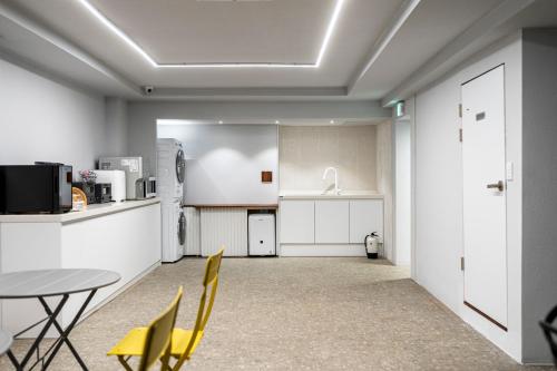 a kitchen with a table and chairs and a refrigerator at Jawoori Hotel Incheon Songdo in Incheon