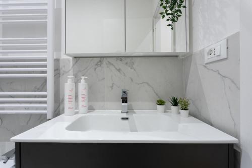 a white kitchen with a sink and white cabinets at Casa del Monumento del Re by Wonderful Italy in Turin