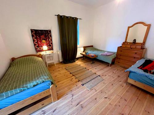 A bed or beds in a room at Dömörkapu Rengeteg Vendégház