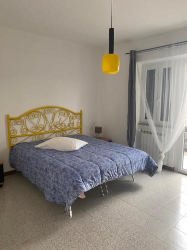 - une chambre avec un lit doté d'une couverture bleue et d'une fenêtre dans l'établissement La casa di Iole, à Casale la Cogna