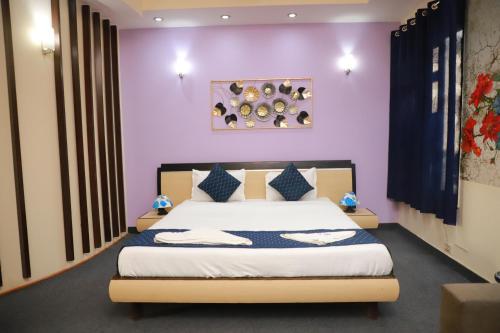 a bedroom with a bed with purple walls at THE REJOICE VENTURE in Gurgaon