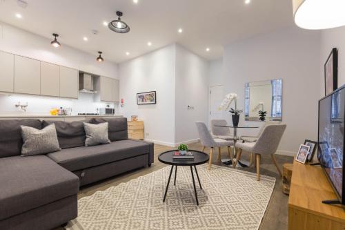 ein Wohnzimmer mit einem Sofa und einem Tisch in der Unterkunft Urban Chic - Rathbone in London