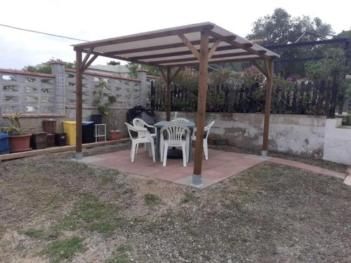 a patio with a table and chairs under a pavilion at Casa Flavio in Porto Pino