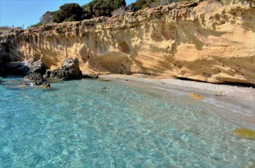 a view of a beach with a rocky cliff at Casa Flavio in Porto Pino
