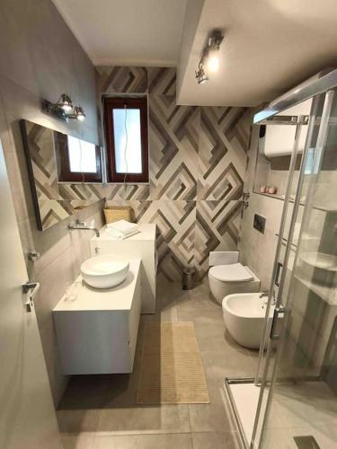a bathroom with two toilets and two sinks in it at Blue Holiday da Carla in Letojanni