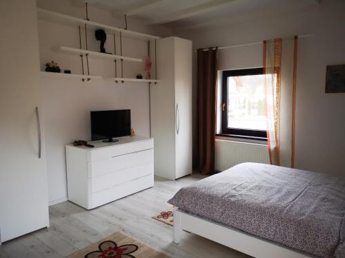 ein Schlafzimmer mit einem Bett und einem TV auf einer Kommode in der Unterkunft Casa din vale in Bran