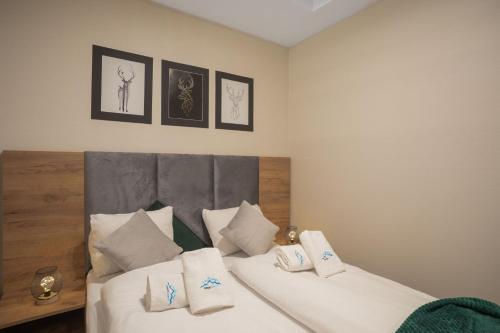 een slaapkamer met 2 bedden met witte lakens en kussens bij Green Park Resort B19- z dostępem do basenu, sauny, jacuzzi, siłowni in Szklarska Poręba
