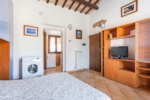 um quarto com uma cama, uma televisão e uma máquina de lavar roupa em Monolocale la casa dei sogni em Chiaravalle