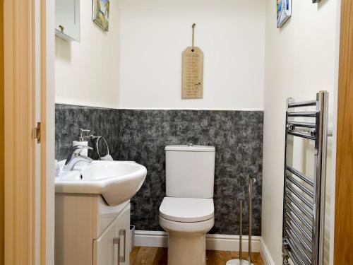 La salle de bains est pourvue de toilettes et d'un lavabo. dans l'établissement Three North Street, à Aldbrough