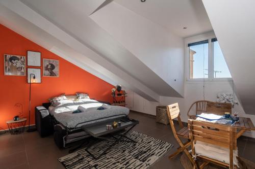 - une chambre avec un lit et un mur orange dans l'établissement Le Laeti - 600m plage - Verrière Côte d'Azur, à Cannes