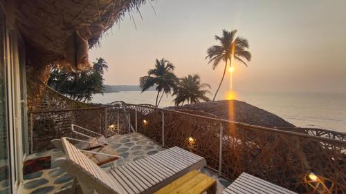 Un balcón con sillas y vistas al océano. en Obrigado by Craftels en Cabo de Rama