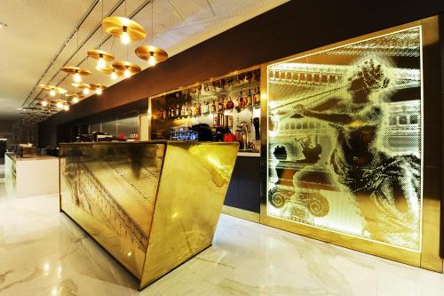 a bar with a large painting on the wall at Mercure Bucharest City Center in Bucharest