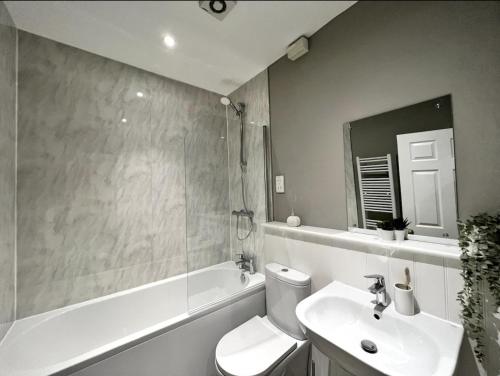 een badkamer met een toilet, een wastafel en een bad bij Luxury Harrogate Flat with Free Parking in Harrogate