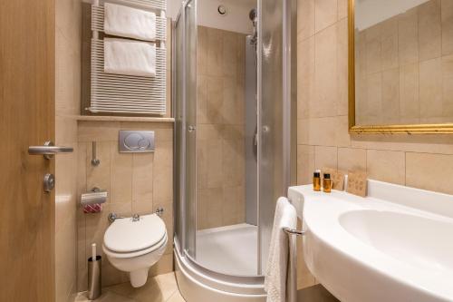 a bathroom with a toilet and a sink and a shower at Hotel Katja in Bibione