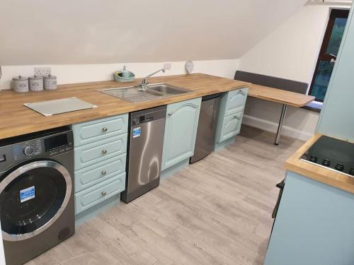 a kitchen with a sink and a washing machine at The Loft, Killybegs in Donegal