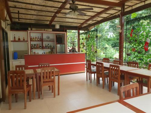 un restaurante con mesas, sillas y una barra en DIAKOPES INN en Puerto Princesa