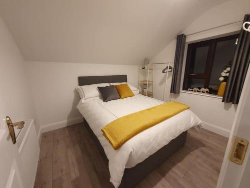 um quarto com uma cama grande e um cobertor amarelo em The Loft, Killybegs em Donegal