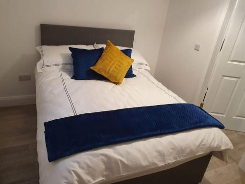 a bed with blue and yellow pillows on it at The Loft, Killybegs in Donegal