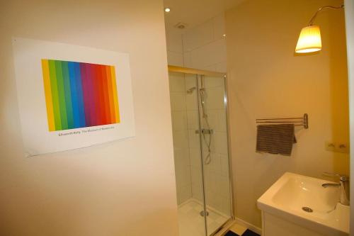 La salle de bains est pourvue d'une peinture arc-en-ciel sur le mur. dans l'établissement Duplex de 3 chambres en plein centre ville - 82/3A, à Liège
