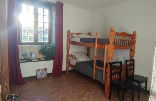 a bedroom with two bunk beds and a window at Gîte Le Relais de la Source in Caro