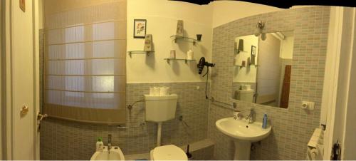 a bathroom with a sink and a toilet and a mirror at Nuovo Cortile Palermo Bed and Breakfast in Palermo