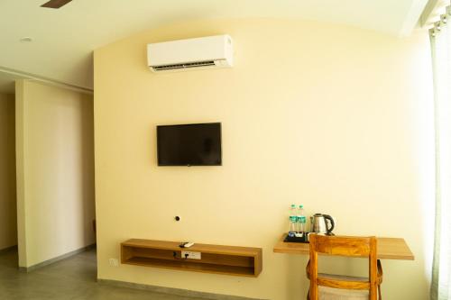 a room with a table and a tv on a wall at Chang's Garden & Resort in Golāghāt