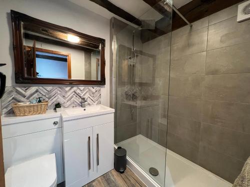 a bathroom with a shower and a sink and a mirror at King Charles Barns Nr Blists Hill in Telford