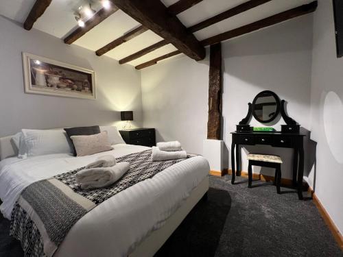 1 dormitorio con cama, espejo y escritorio en King Charles Barns Nr Blists Hill en Telford