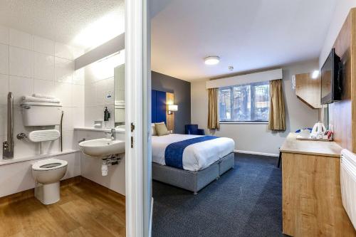 a hotel room with a bed and a sink at Days Inn London Stansted Airport in Stansted Mountfitchet