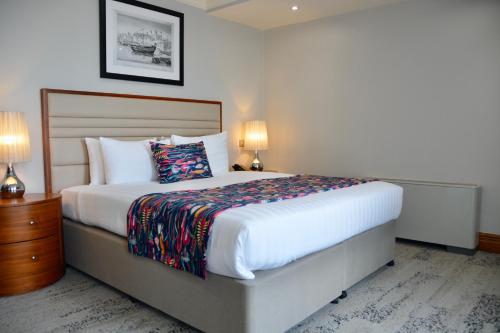 a bedroom with a large bed and two lamps at Sanctum Maida Vale in London