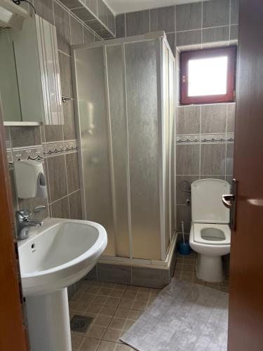 a bathroom with a sink and a toilet and a shower at Ribarska Priča-Restoran pansion Prijedor in Prijedor