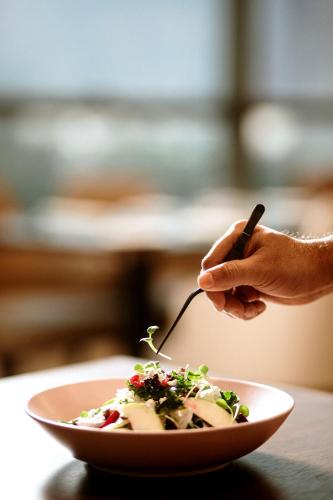 a person eating a bowl of food with a fork at Courtyard by Marriott Navi Mumbai in Navi Mumbai