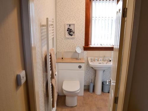 a small bathroom with a toilet and a sink at Thain House in Banff