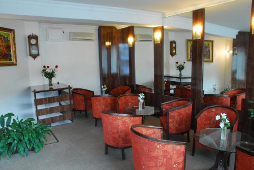 a restaurant with red chairs and tables in a room at Noviz Hotel in Plovdiv