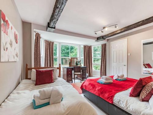 um quarto com 2 camas em vermelho e branco em Questeds em Westgate on Sea