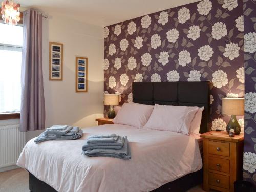 1 dormitorio con 1 cama con toallas en Thain House en Banff