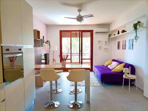 a living room with a purple couch and a kitchen at Blue Holiday da Marco in Letojanni