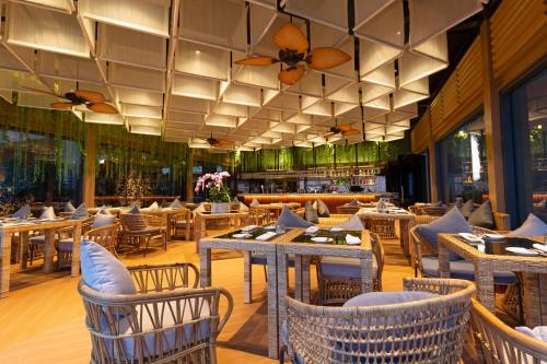 a restaurant with tables and chairs and a bar at SUN & MOON, Riverside Hotel in Phnom Penh