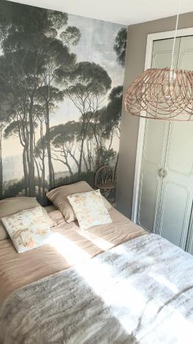 une chambre avec un lit avec un tableau sur le mur dans l'établissement Petite chambre coquette, à Cellettes
