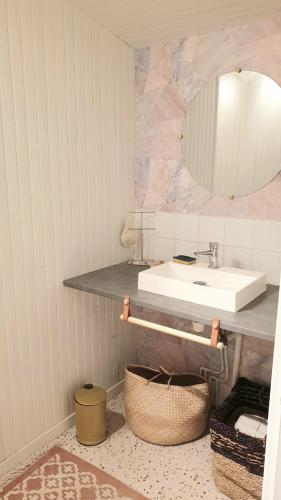 une salle de bain avec un lavabo et un miroir dans l'établissement Petite chambre coquette, à Cellettes